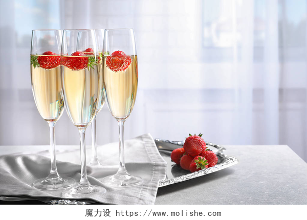 白色背景中桌子上的三杯香槟和草莓美味的葡萄酒，与草莓 
